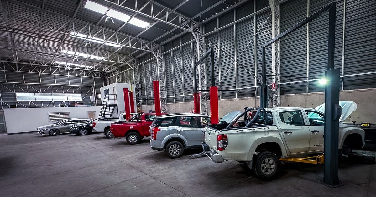 Bahía de trabajo con elevadores y camionetas en el servicio técnico automotriz Fourtech, Quilicura