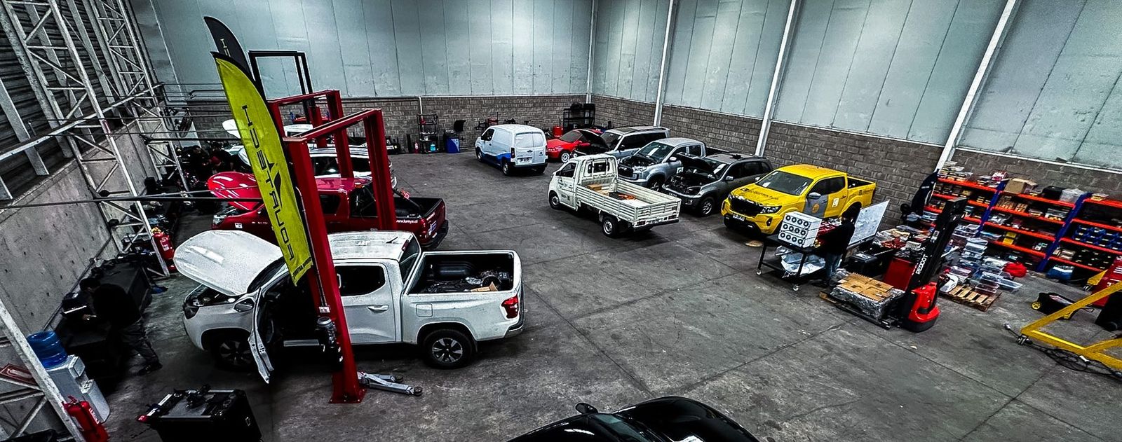 Vista general del servicio técnico automotriz multimarca Fourtech en Quilicura, con camionetas, furgones y autos en mantención